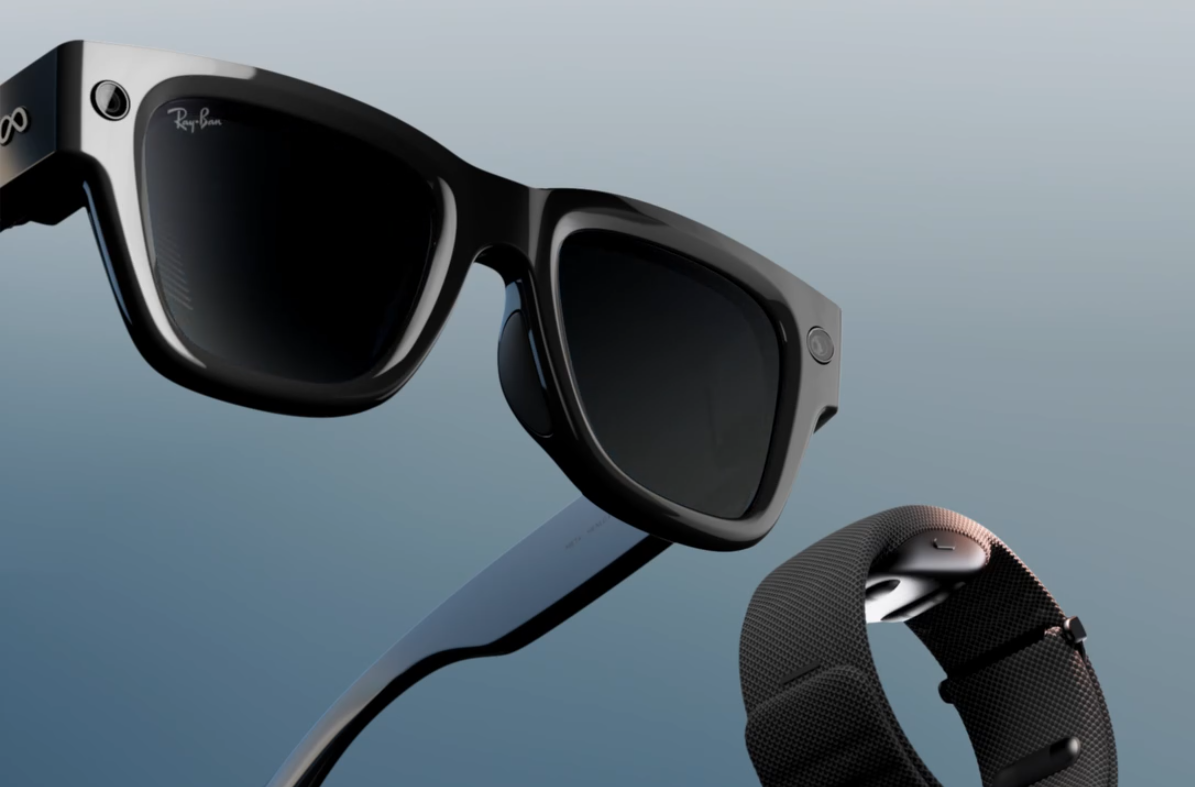 Close-up of black Ray-Ban smart glasses with Meta logo, paired with a black wearable band against a gradient background.