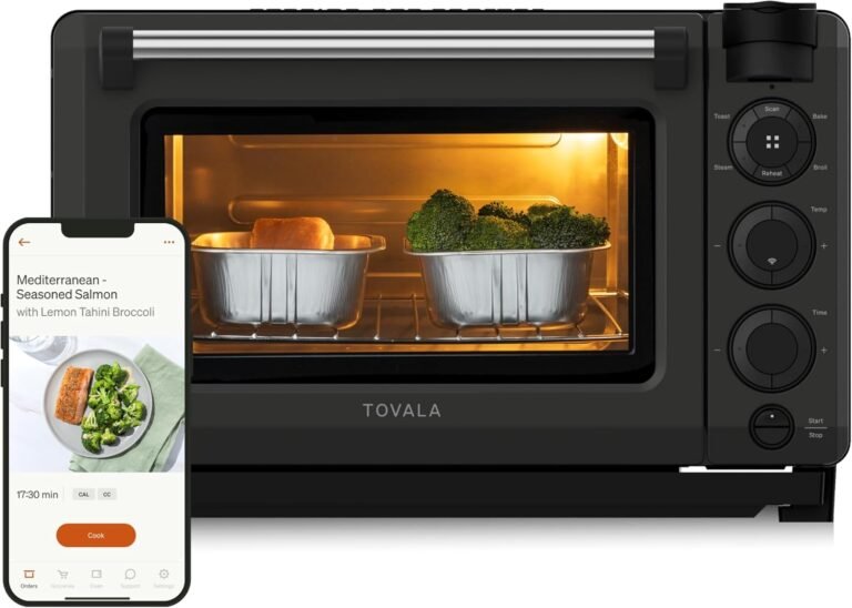 Tovala Oven Pro smart countertop oven with two trays inside, one containing salmon and the other broccoli, illuminated by the oven light. Next to it, a smartphone screen shows the Tovala app displaying a recipe for “Mediterranean Seasoned Salmon with Lemon Tahini Broccoli” and a cooking timer.